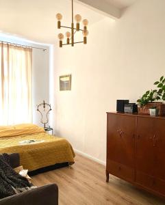 a bedroom with a bed and a dresser and a chandelier at Apartament Hygge Monte Cassino 4 in Szczecin