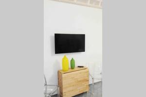 uma sala de estar com televisão numa parede branca em Il Cortiletto su levanzo em Favignana