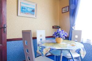 a table and chairs with a vase of flowers on it at Orange Flower Apartments in Sofia