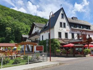a large white building on the side of a street at Moselhotel Waldeck in Burgen