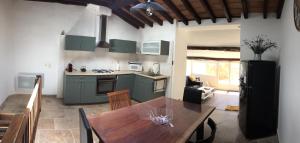 a kitchen and dining room with a wooden table at Chez Marius Gordes Vue panoramique sur luberon in Gordes