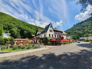 un edificio al lado de una carretera junto a una montaña en Moselhotel Waldeck, en Burgen