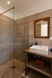 a bathroom with a sink and a glass shower at Maison Tavolara in Porto-Vecchio
