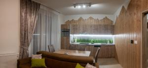 a living room with a table and a kitchen at Magic Bernard, Starý Smokovec in Starý Smokovec