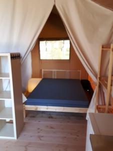 ein Schlafzimmer mit einem Bett in einem Zelt in der Unterkunft Camping Oos Heem in Montenau