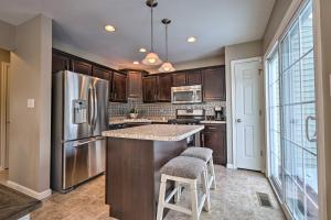 a kitchen with wooden cabinets and a stainless steel refrigerator at Bellefonte Townhouse - 9 Miles to Penn State! in Bellefonte