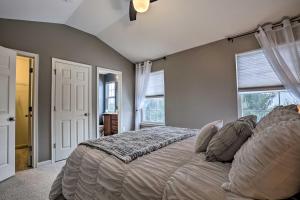 a bedroom with a bed and two windows at Bellefonte Townhouse - 9 Miles to Penn State! in Bellefonte