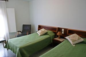 a bedroom with two green beds and a chair at Casa Rural Cal Met in Sant Boi de Lluçanès +21 photos