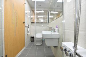 a bathroom with a toilet and a sink and a shower at Sokcho Daemyung Heidi Pension in Sokcho