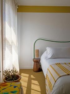 a bedroom with a bed and a window at Hôtel Le Sud in Juan-les-Pins