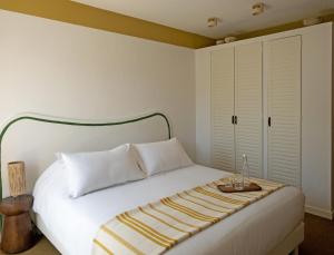 a bedroom with a white bed with a blanket on it at Hôtel Le Sud in Juan-les-Pins