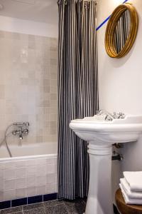 a bathroom with a sink and a shower curtain at Hôtel Le Sud in Juan-les-Pins