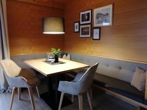 una mesa y sillas en una habitación con paredes de madera en Huber - Das Tiroler B&B, en Oberperfuss