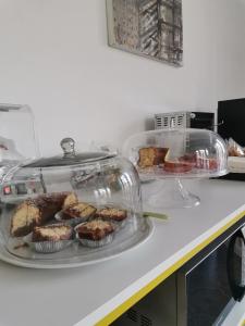 zwei Tabletts Essen auf einer Theke mit Muffins in der Unterkunft Ace Rooms VSG in Villa San Giovanni