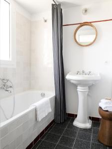 a bathroom with a tub and a sink at Hôtel Le Sud in Juan-les-Pins