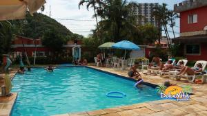 een groep mensen die in een zwembad zitten bij Pousada Dolce Vita in Itanhaém