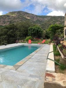 een zwembad met een berg op de achtergrond bij Villa Capraghjese in Galeria