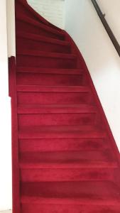 
a red and white staircase leading to a stairwell at Sewdien's Apartment Beverwaard in Rotterdam
