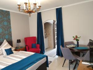 a bedroom with a bed and a table and chairs at Titi Classic & Trendy Apartman in Bük