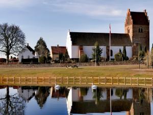 un edificio accanto a un corpo idrico di Villa Wolte Bed and Breakfast a Ringsted