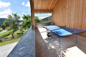 un tavolo da ping pong si trova sul patio di una casa. di Wiesenhof Rusch ad Alberschwende