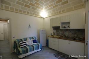 uma cozinha com um sofá num quarto com um balcão em Il Cortiletto su levanzo em Favignana
