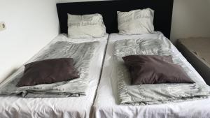 1 cama individual con 2 almohadas encima en Sewdien's Apartment Beverwaard, en Róterdam