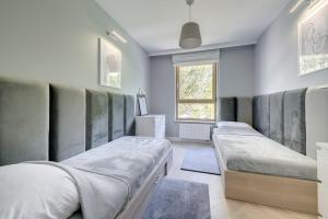 a bedroom with two beds and a window at 3 City apartments - Syma in Sopot