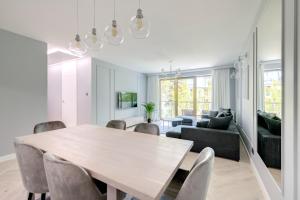 a dining room and living room with a table and chairs at 3 City apartments - Syma in Sopot