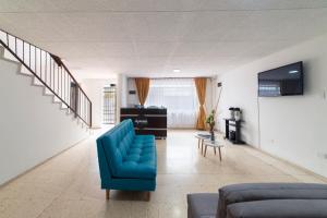 sala de estar con sofá azul y mesa en Ayenda 1055 Agora INN Corferias, en Bogotá