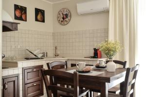 uma cozinha com uma mesa de madeira com cadeiras e uma mesa; em Filomena Suite Luxury Apartment em Catânia