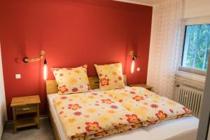 um quarto com paredes vermelhas e uma cama com lençóis amarelos em friends & family Domizil Willingen em Willingen