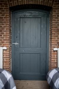 a green garage door in a brick building at Kerkovernachting in Schettens +5 photos
