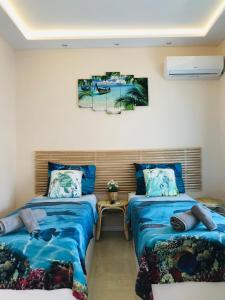 Dos camas en una habitación con sábanas azules. en Relax Apartment, en Perea