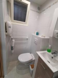 a white bathroom with a toilet and a sink at Nice - Charming little house with terrace in Nice