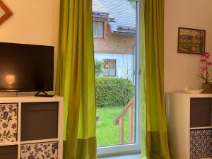 un soggiorno con TV e una grande finestra di Alpen Apartement a Hallstatt