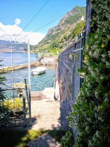 a person standing next to a wall next to the water at La Casina a Remi in Marone