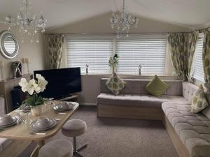 a living room with a couch and a tv at Pack and go holidays in Ingoldmells