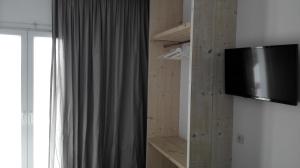 uma televisão numa parede num quarto em Anamar Santorini em Monolithos