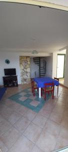 een woonkamer met een blauwe tafel en een open haard bij Villa Anna, con patio vista mare in Castellammare del Golfo