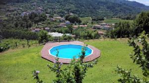 una imagen de una piscina en un campo en Quinta da Mata, en Ponte da Barca