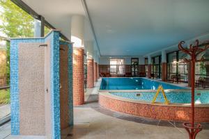a swimming pool in a building with a brick wall at The Bluedeck Wellness Apartment in Balatonfüred