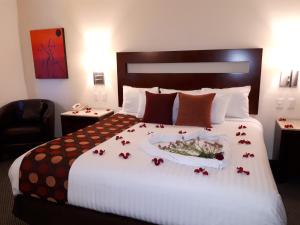 Una habitación de hotel con una cama con una bandeja con flores. en Hotel Ankara "Las Lomas" en San Luis Potosí