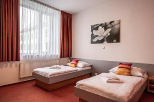 a hotel room with two beds and a window at Ruby Blue in Ostrava