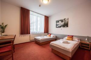 a hotel room with two beds and a desk at Ruby Blue in Ostrava