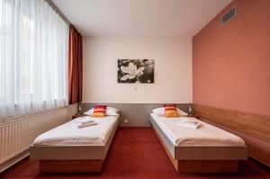 two twin beds in a room with a window at Ruby Blue in Ostrava