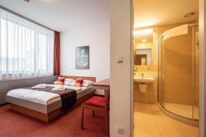 a hotel room with a bed and a bathroom at Ruby Blue in Ostrava