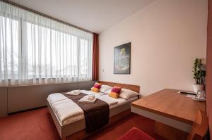 a bedroom with a bed and a table and a window at Ruby Blue in Ostrava