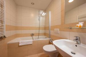 a bathroom with a tub and a toilet and a sink at Ruby Blue in Ostrava