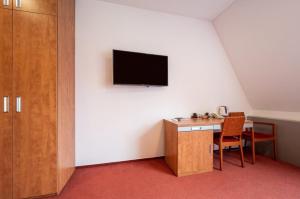 a room with a desk and a tv on a wall at Ruby Blue in Ostrava